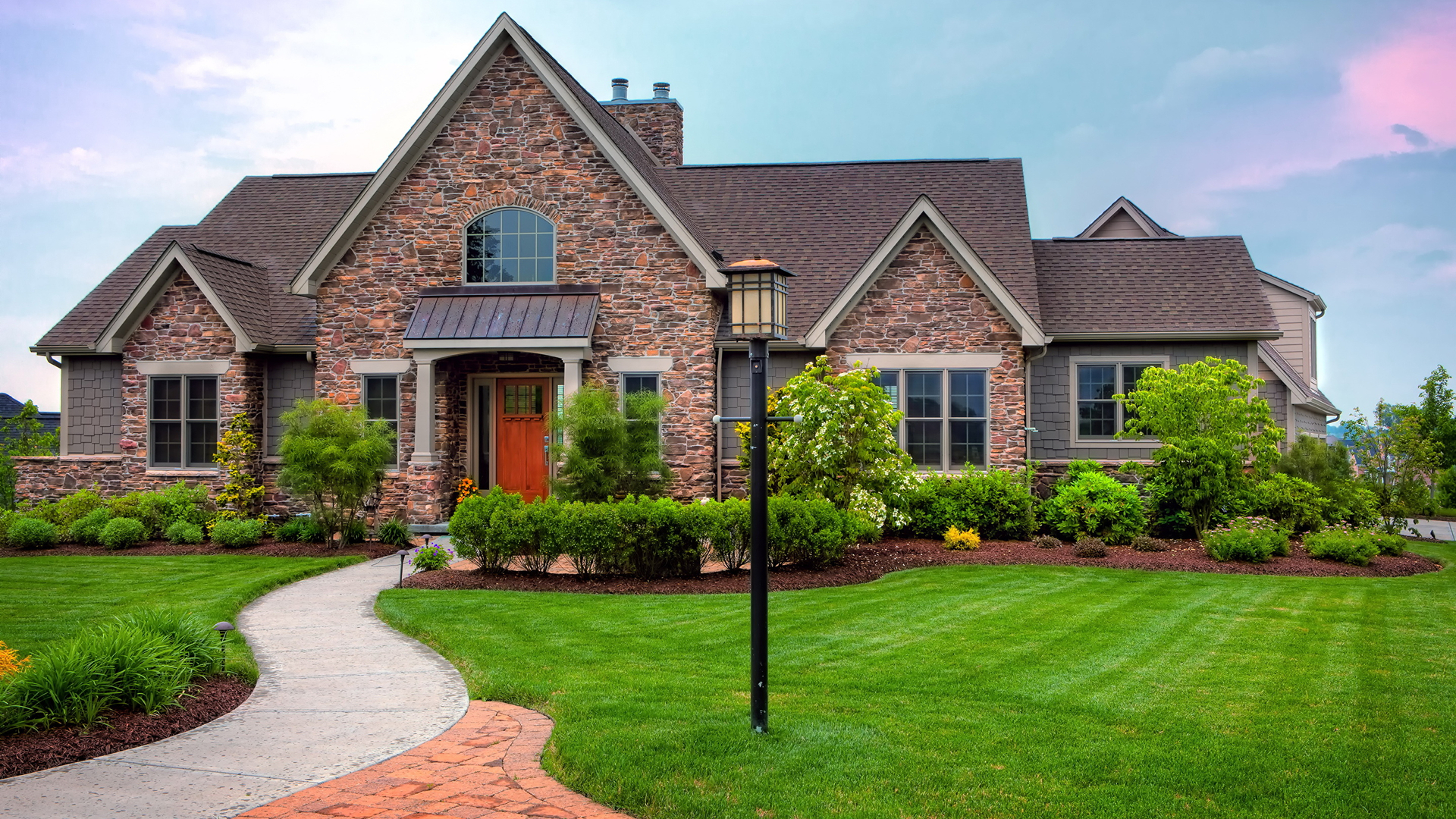 A stone home with a healthy green lawn located in Sanatoga, PA. 