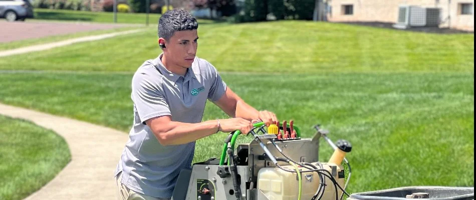 Professional in Telford, PA, applying fertilizer treatment on a lawn.